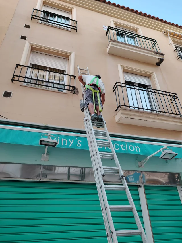 Trabajo real de pintura y mantenimiento de fachada realizado con medidas de seguridad